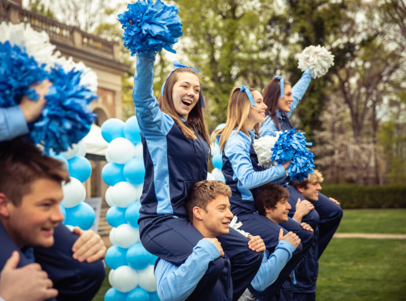 cheerleaders standing in front of the bell tower