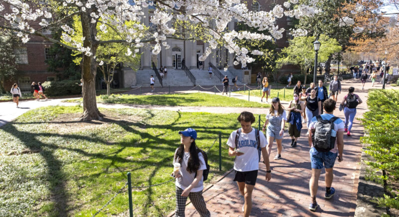 Students walk on a brick path on the campus of the University of North Carolina at Chapel Hill.