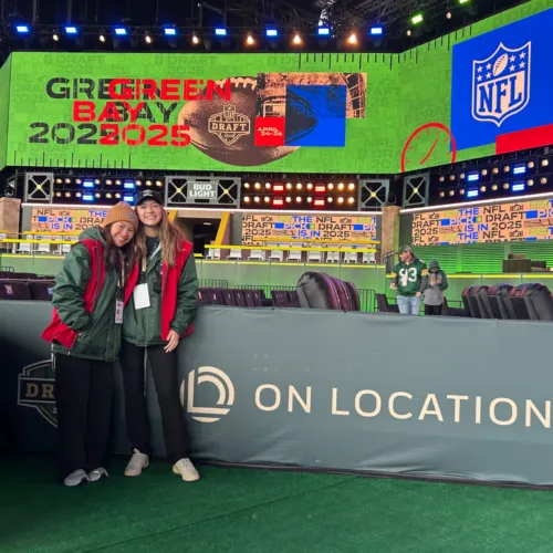 Two students in front of a jumbotron for NFL Draft