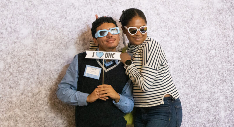 Two scholarship students posing with an "I Love UNC" sign at the 2023 Scholarship Celebration at the George Watts Hill Alumni Center.