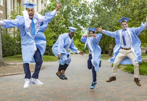 (Left to right) Graduating seniors Michael Leary, Jordon Reynolds, Art Baghel and Peter Morrow jump for a portrait on April 23, 2021, on the campus of the University of North Carolina at Chapel Hill. (Johnny Andrews/UNC-Chapel Hill)