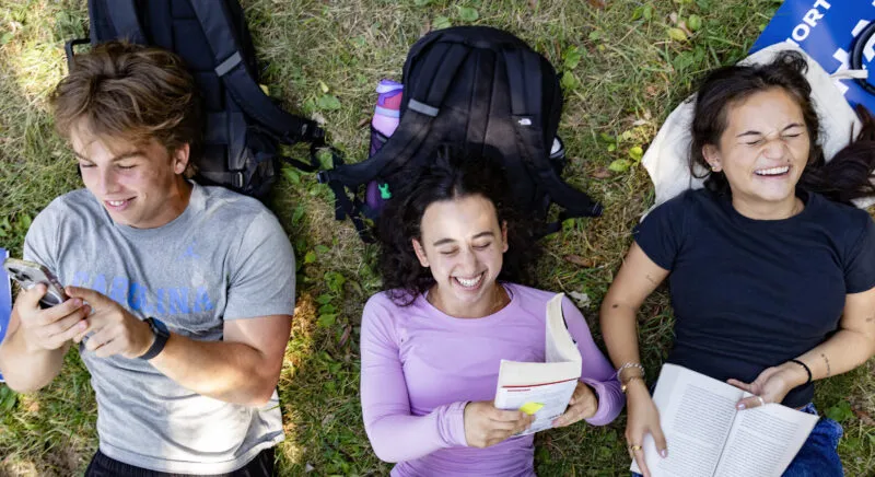 Scenes from Polk Place on September 10, 2024, on the campus of the University of North Carolina at Chapel Hill. In this image, first-year students (left to right) John Harmon, Shayna Whitney and Kylie Southivongnorath hang out on Polk Place.
