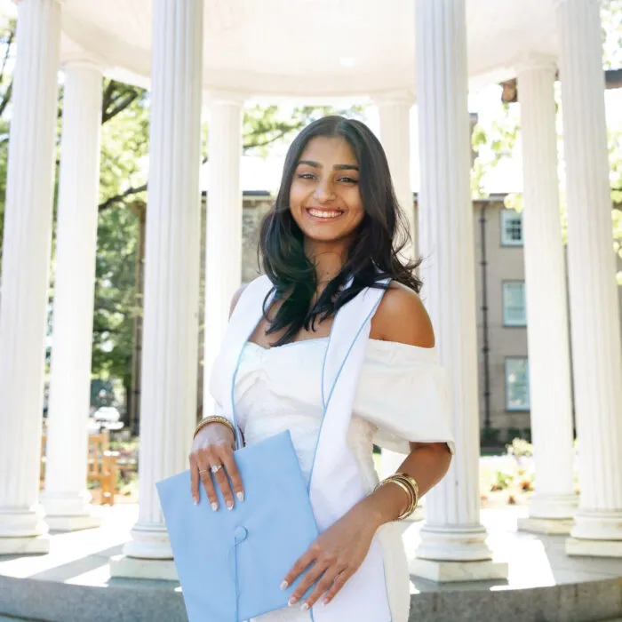 Keerthana Standing with her graduation Cap in front of the Old Well
