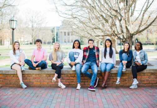 Students sitting on a low stone wall at UNC