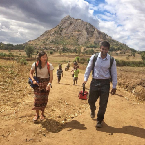 Two public health professionals walking and talking in Malawi.
