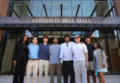 Students stand outside of the business school