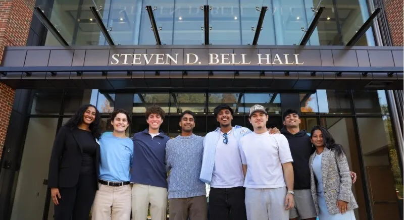 Students stand outside of the business school