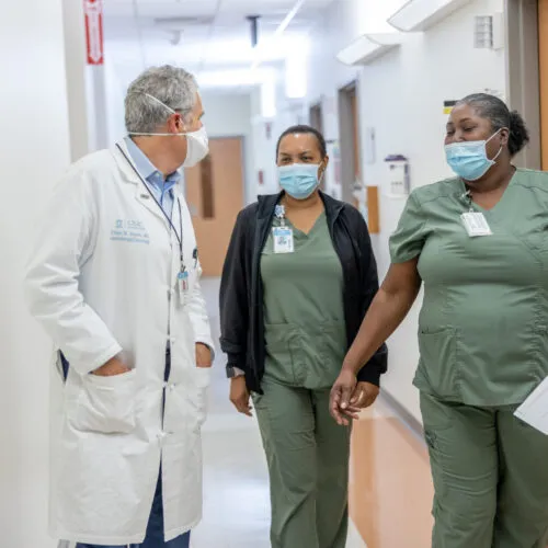 Medical staff walk down hallway