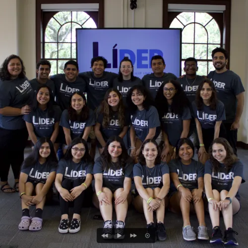Group of individuals wearing Lider shirts positioned in three rows for a posed photo.