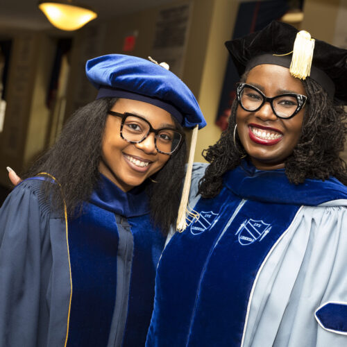 Two UNC School of Social Works grads are pictured in caps and gowns.