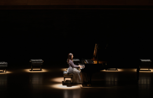 Piano player on stage with spotlight