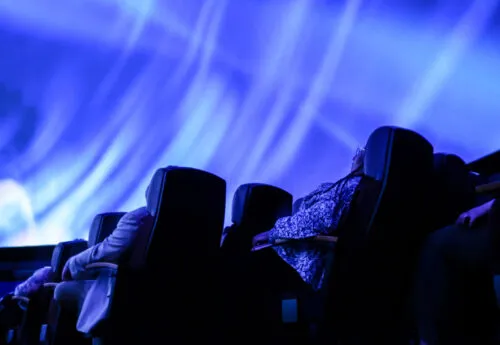 Patrons stare at the planetarium ceiling during a show