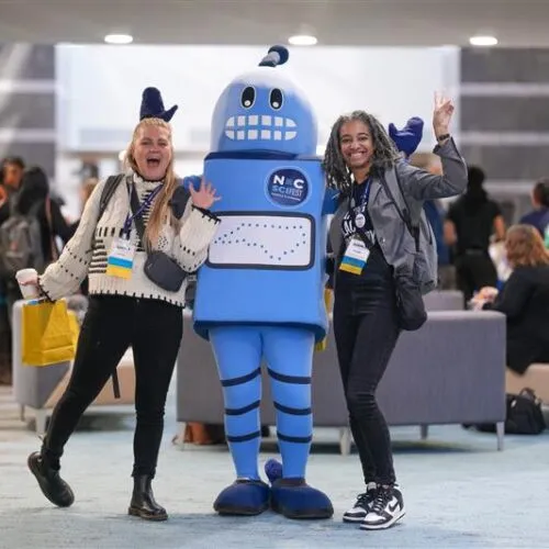 Two students pose with a person in a robot costume at NC Scifest