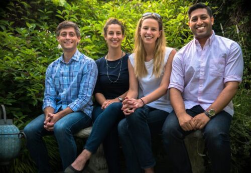 A group of four students sitting outside