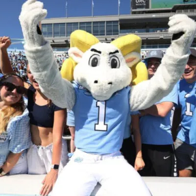 Ramses standing in front of students in the football stadium