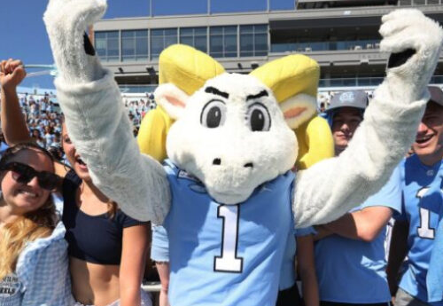 Ramses standing in front of students in the football stadium