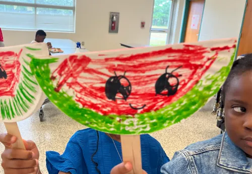 kids holding watermelon drawing on popsicle sticks