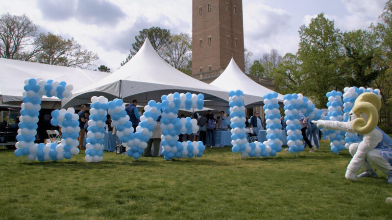 GiveUNC spelled out in balloons with ramses pointing