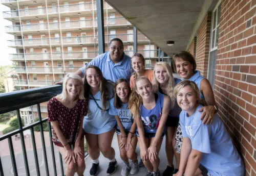 Group of Carolina Students posing in front of a dorm.