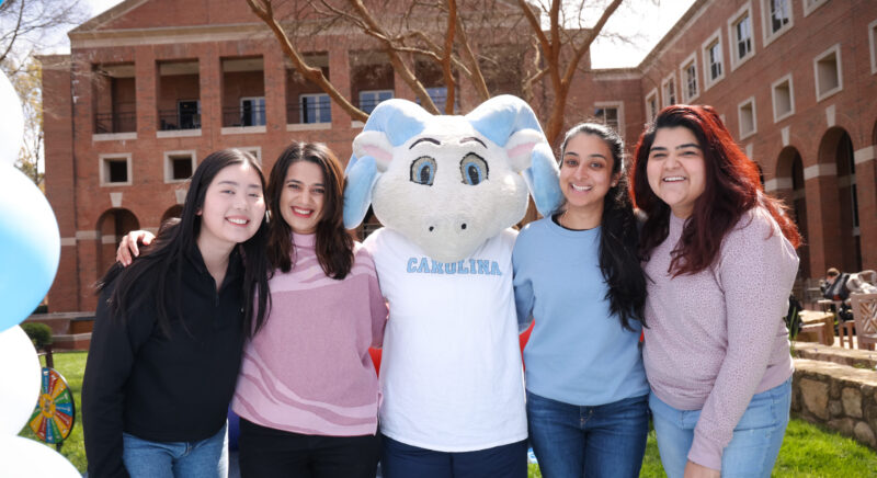 Kenan Flagler Business School Students stand with UNC Mascot RJ.