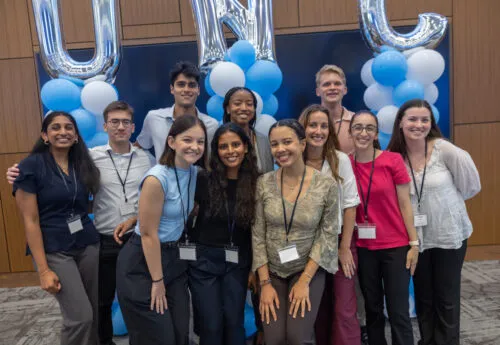 School of Medicine faculty and staff smile in front of a UNC balloon arch